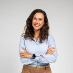 Smiling friendly confident millennial caucasian lady manager, teacher in formal wear with crossed arms on chest, isolated on gray background studio background. Work, study, courses and business